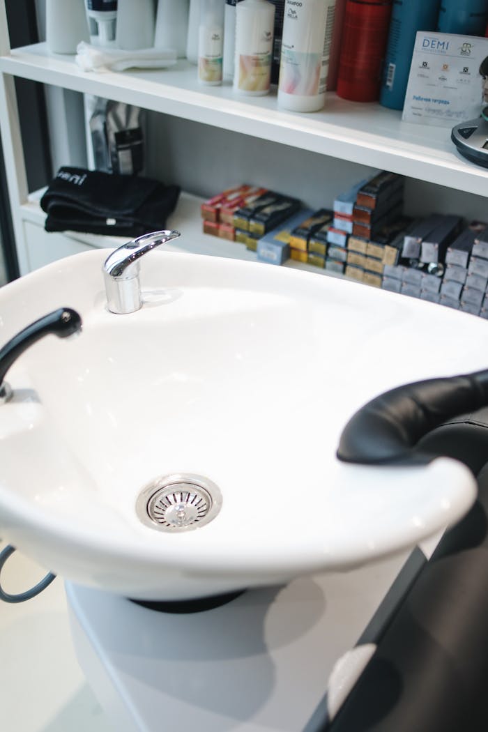 A stylish hair salon shampoo station with products on shelves.